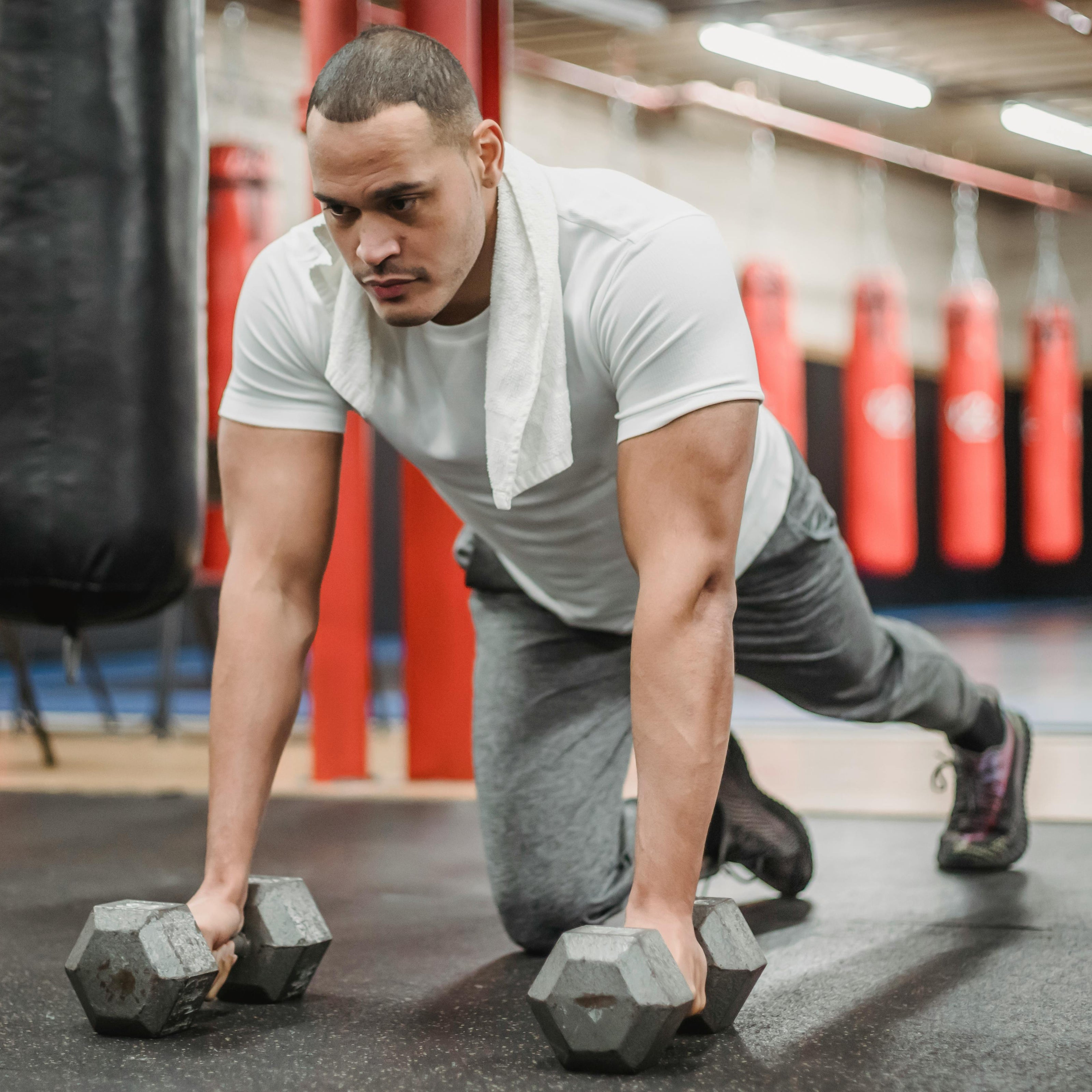 Man exercising with dumbbells in a gym setting